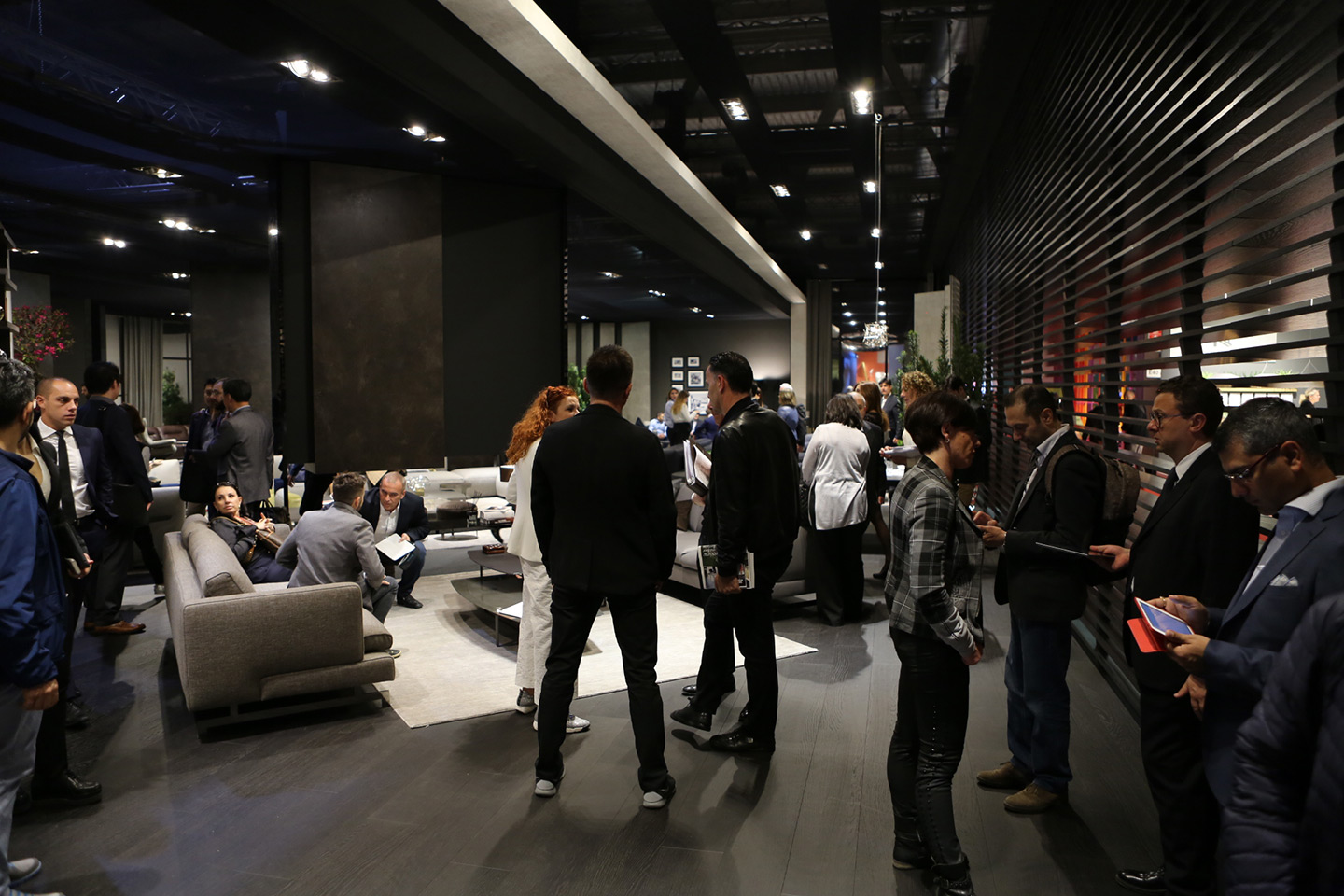 visitatori allo stand di Natuzzi alla Milano Design Week che parlano tra di loro